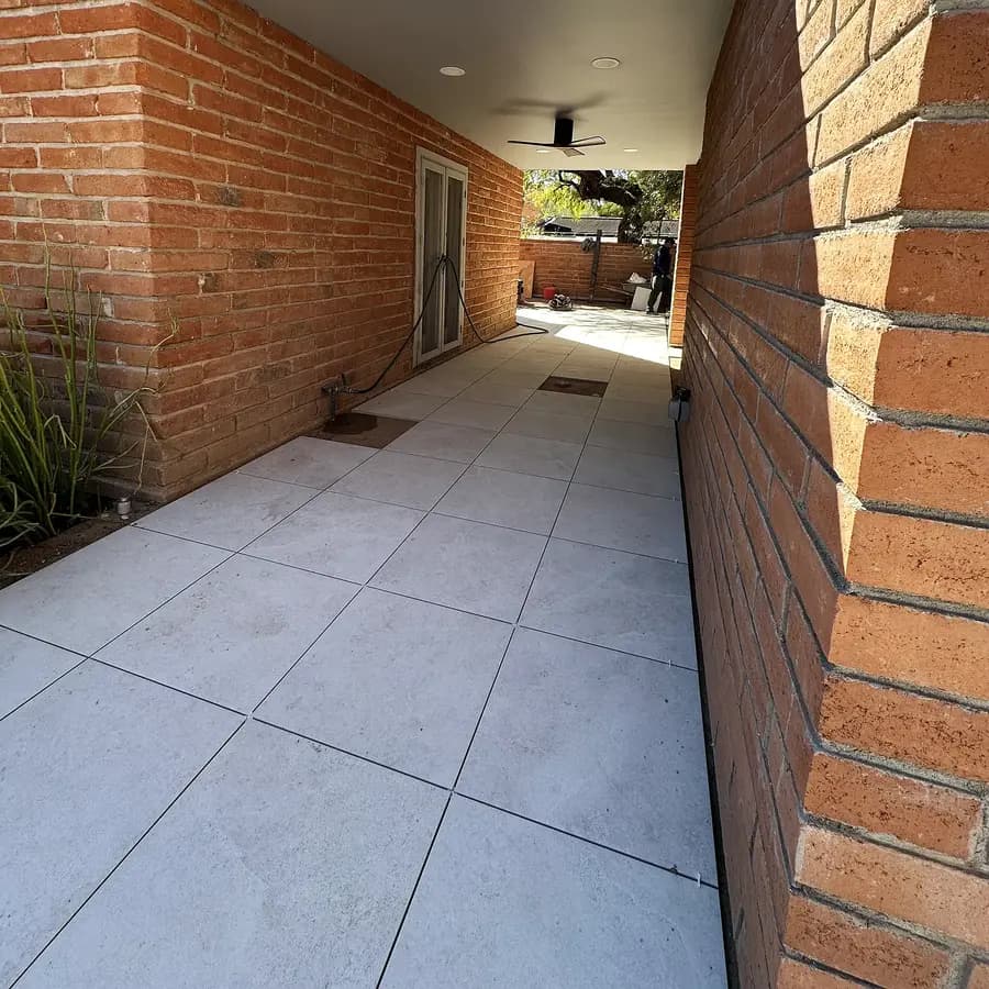 Close-up of large-format porcelain paving beside a clay brick wall